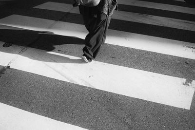 Low section of a woman crossing road