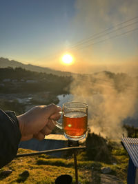 Friend enjoying tea and sunrise in cold and amazing morning
