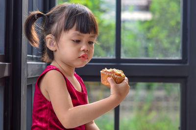 Girl eating food on window