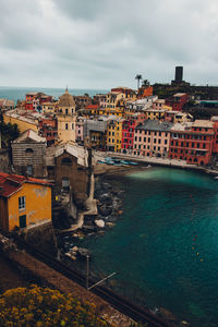 High angle view of townscape by sea against sky