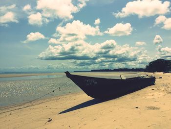 Scenic view of beach against cloudy sky