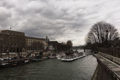 City at waterfront against cloudy sky