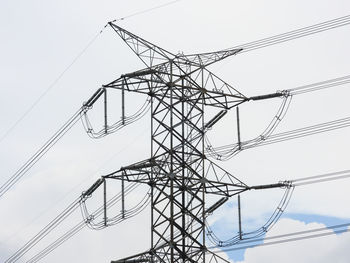 Low angle view of electricity pylon against sky