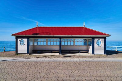 Built structure on beach against blue sky