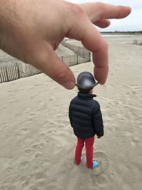 Close-up of boy holding sand at beach