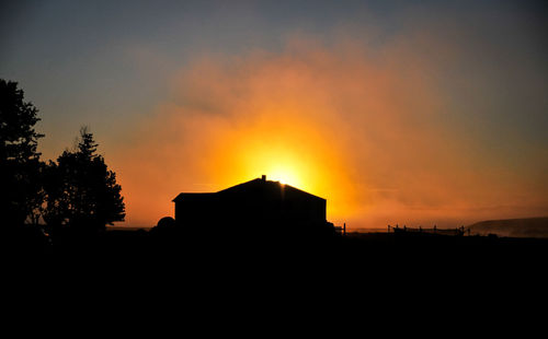 Silhouette buildings against sky during sunset