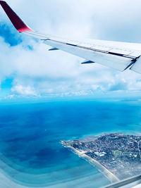 Airplane flying over sea against sky