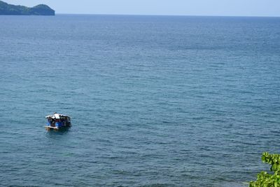 Boat sailing in sea against clear sky