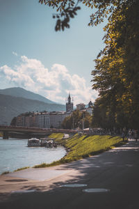 Bridge over river by buildings against sky