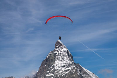 Low angle view of person paragliding against sky
