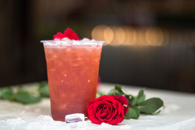 Close-up of rose in glass on table
