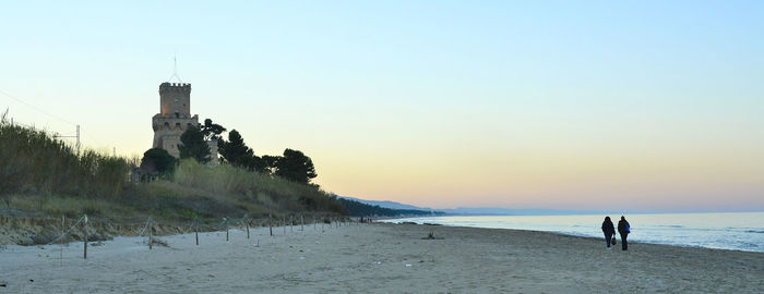 Scenic view of sandy beach against sky at sunset