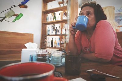 Man holding coffee cup on table at home