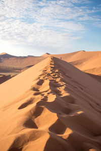 Sand dunes in desert against sky