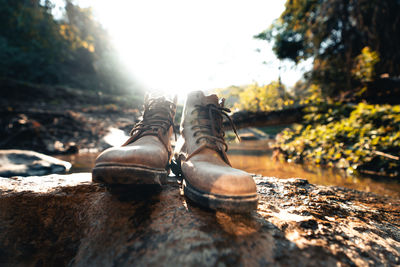 Close-up of boot on rock at river