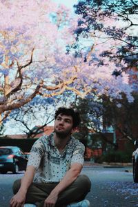 Portrait of young man sitting on street
