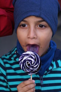 Close-up of cute boy licking lollipop