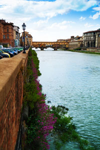 River amidst buildings in city against sky