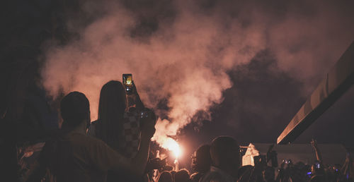 People at concert against sky during night