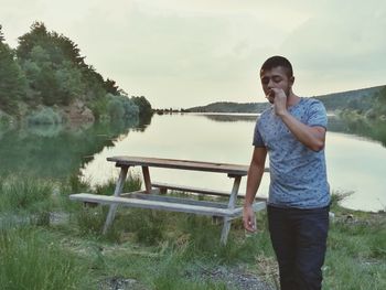 Portrait of smiling man standing by lake