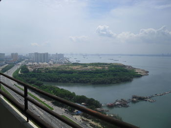 High angle view of city by sea against sky