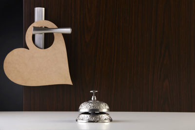 Close-up of electric lamp on table against wall