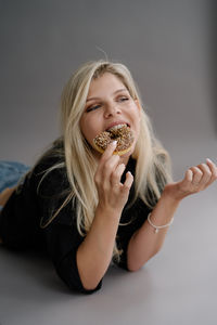 Portrait of young woman eating food at home