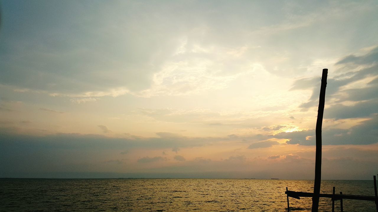 sea, horizon over water, sky, scenics, tranquil scene, water, tranquility, sunset, beauty in nature, cloud - sky, nature, idyllic, cloud, silhouette, beach, cloudy, calm, seascape, outdoors, pier