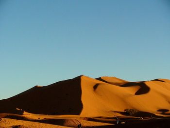 Scenic view of desert against clear blue sky