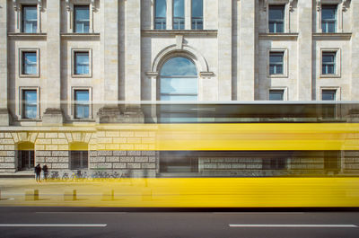 Blurred motion against yellow building