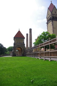 Lawn in front of building against sky