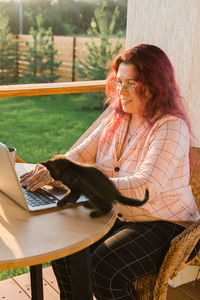 Young woman using laptop at cafe