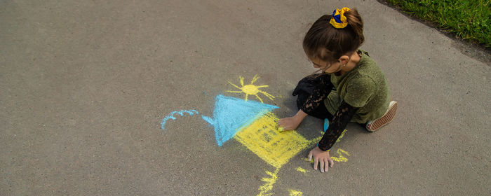 High angle view of girl drawing on road