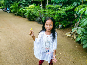 Portrait of girl standing against plants