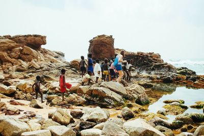 Woman and children walking on rocks at beach