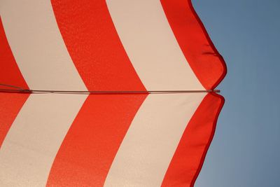 Low angle view of red umbrella against blue sky