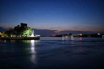 View of city at waterfront at night