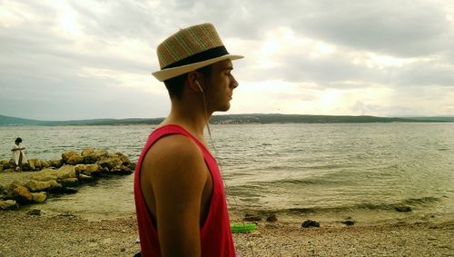 Close-up of man standing on beach against sky