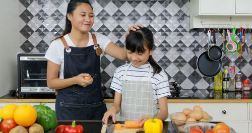 Full length of mother and daughter standing on floor