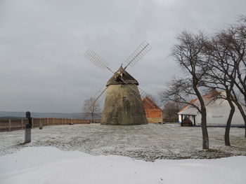 Traditional windmill on field against sky