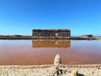 Built structure on beach against clear blue sky