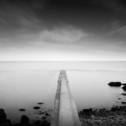 Pier amidst sea against sky