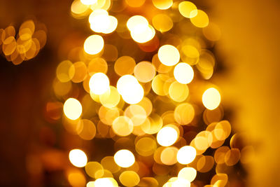 Defocused image of illuminated christmas lights at night