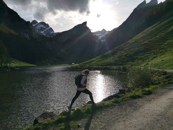 Rear view of man on road by mountains against sky