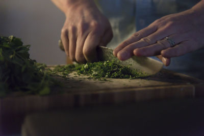 Midsection of person preparing food on cutting board