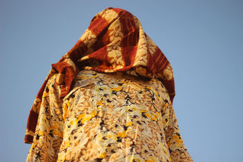 Low angle view of woman standing against clear sky