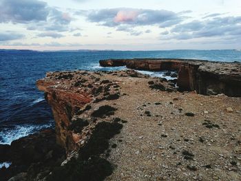 Rock formation on beach against sky