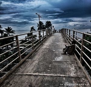 View of footbridge over sea against sky