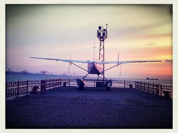 Pier on sea at sunset