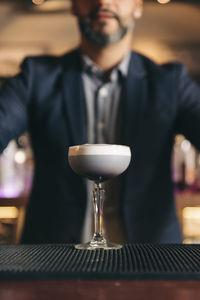 Male bartender with cocktail at bar counter